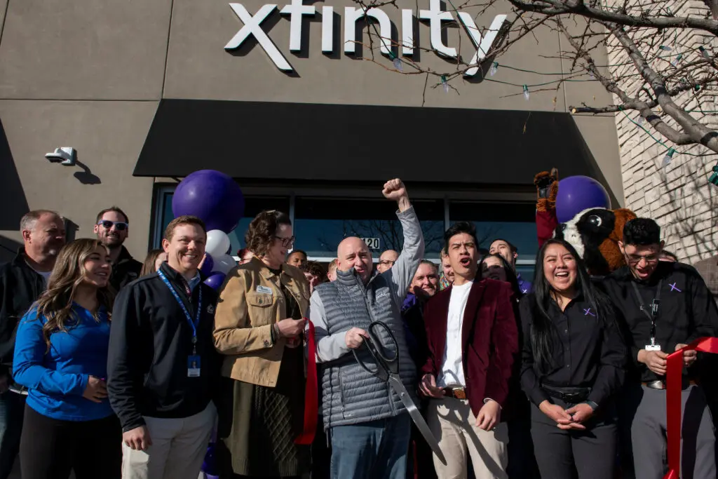 Comcast employees and city leaders cutting a ribbon outside the new Xfinity Store in Fort Collins.