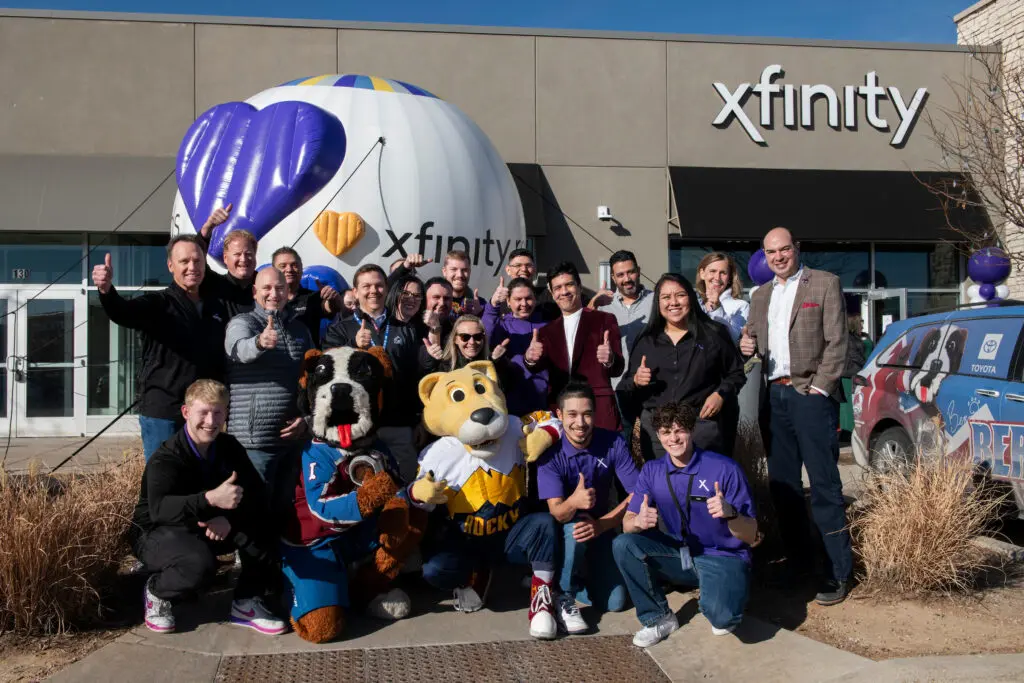 Bernie and Rocky, mascots for the Colorado Avalanche and Denver Nuggets, and Comcast employees posing outside of the new Xfinity store in Fort Collins.