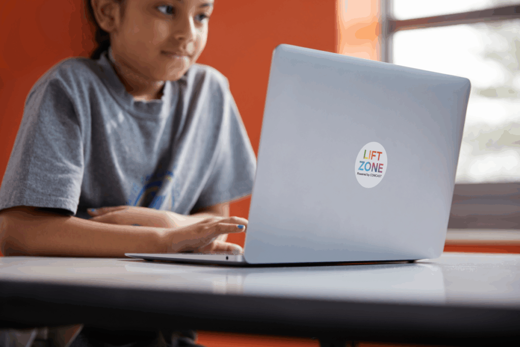 Student using a laptop at a Comcast Lift Zone.
