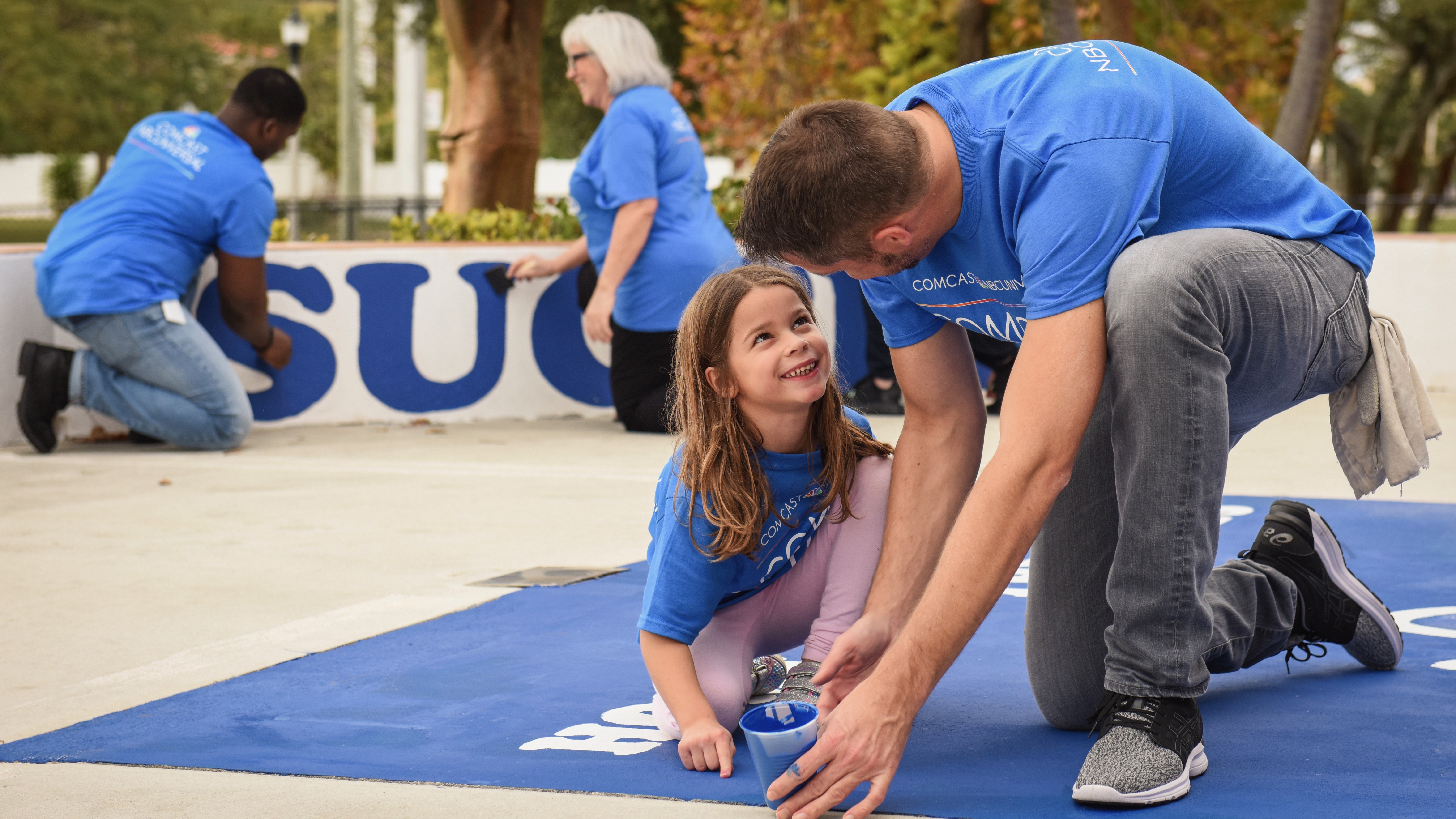 Comcast Cares Day volunteers paint a playground.