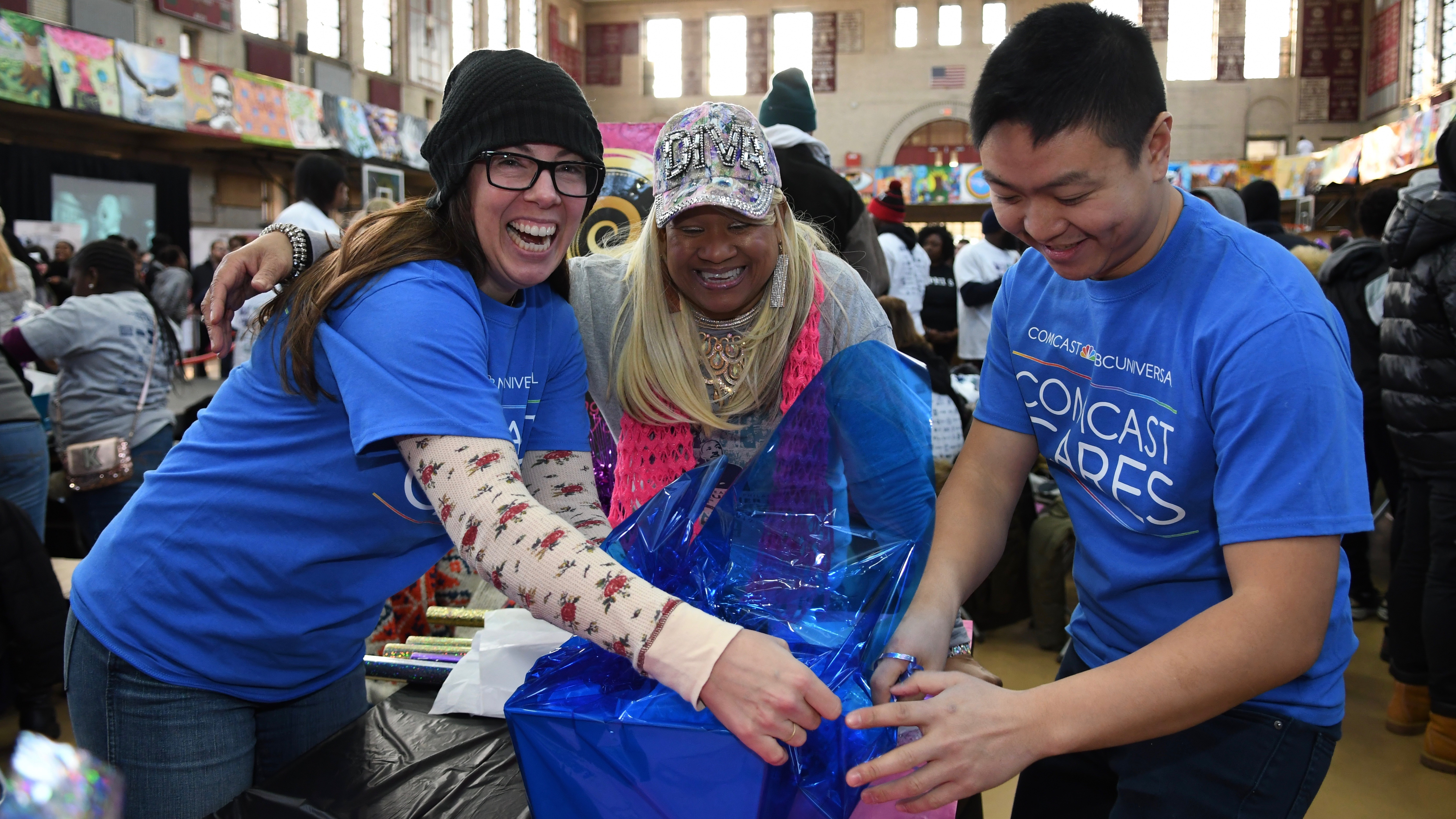 Comcast Cares Day volunteers wrap gifts.