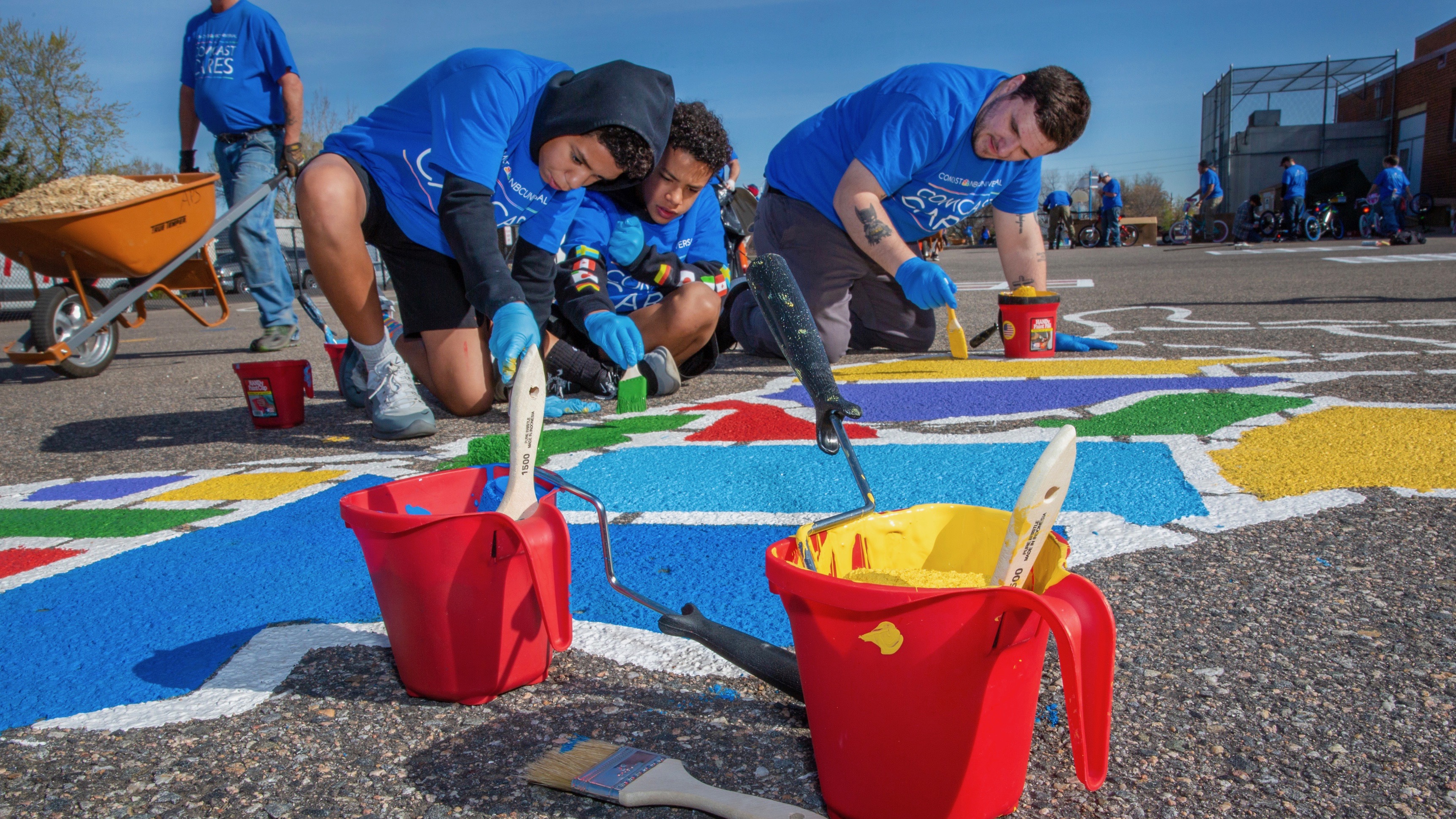 Comcast Cares Day volunteers paint a playground.