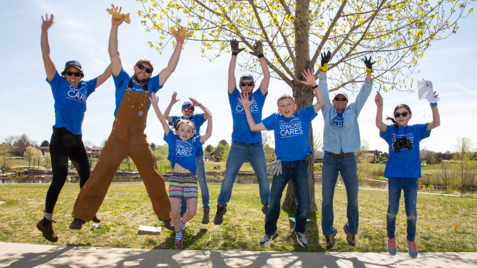 Comcast Cares Day volunteers jump in the air.