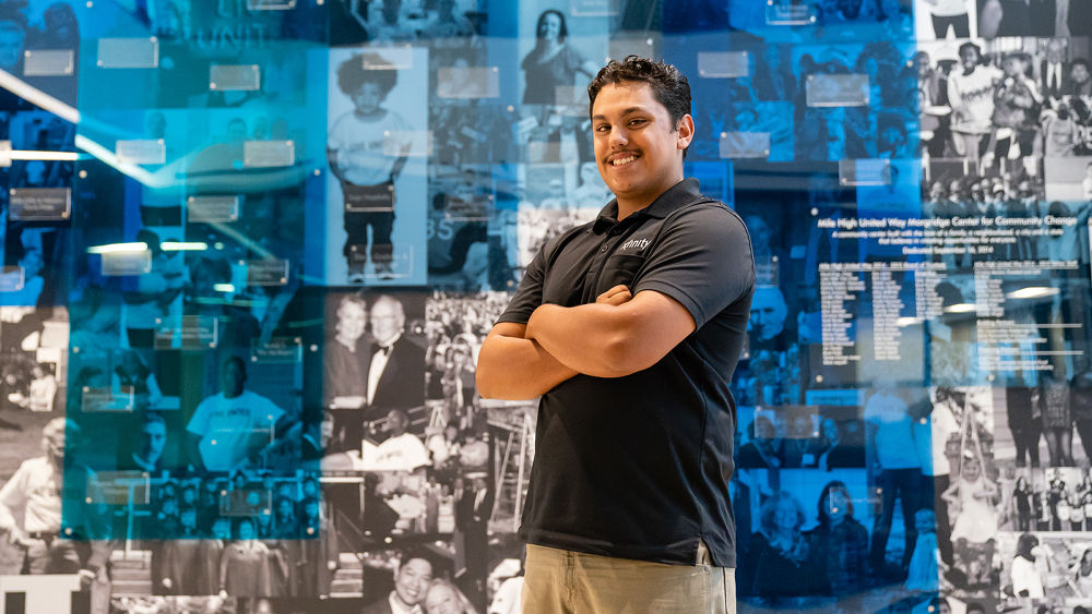 A United Way participant poses in front of a mural.