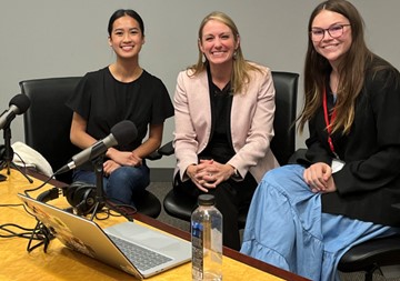 Rachel Solomon posing for a photo with the hosts of the STEMblazers Podcast.