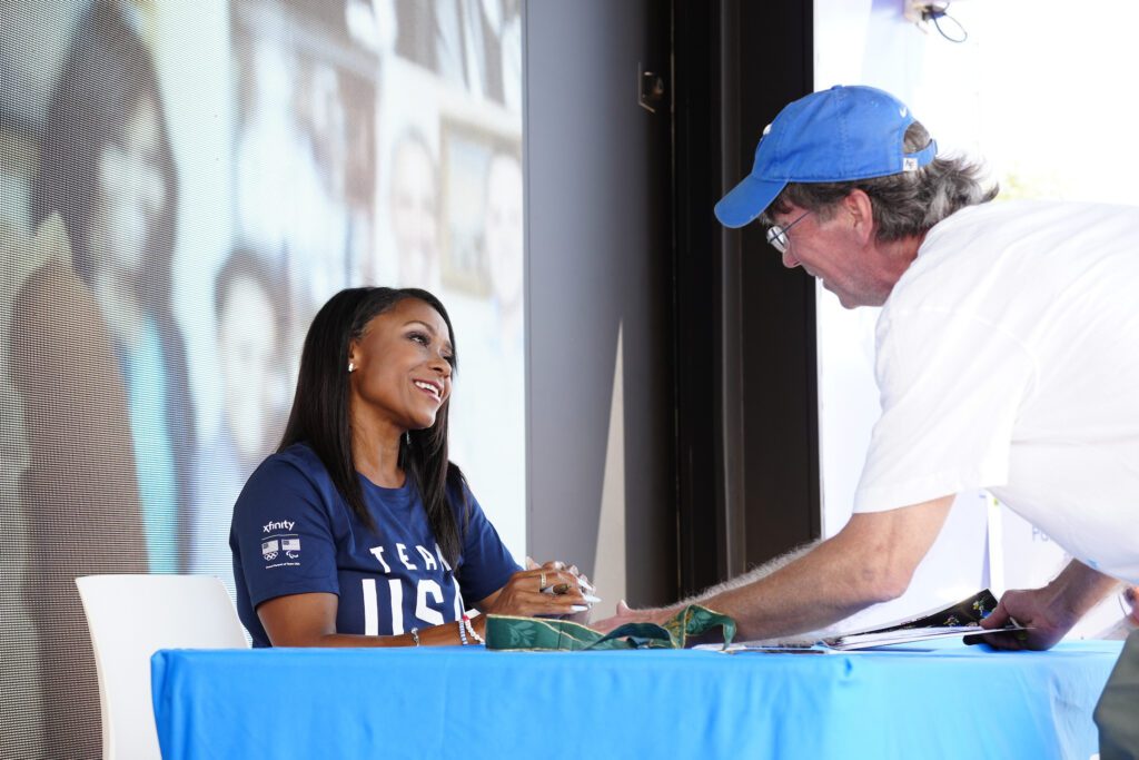 Four-time Olympic medalist Dominique Dawes greets a fan at Downtown Summerfest in Colorado Springs.