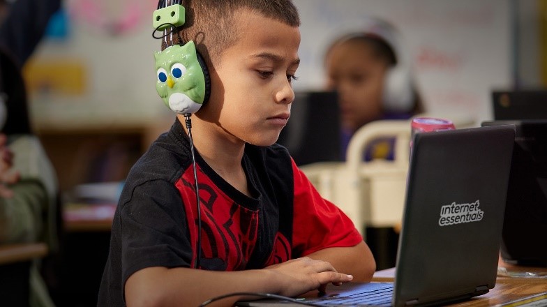 Student using laptop with Internet Essentials branding